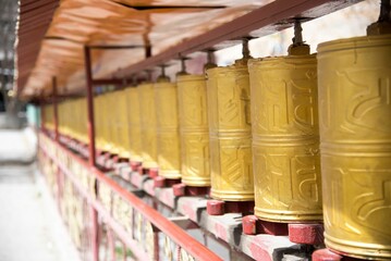 Close up of rows of prayer bells hanging in an ancient temple.