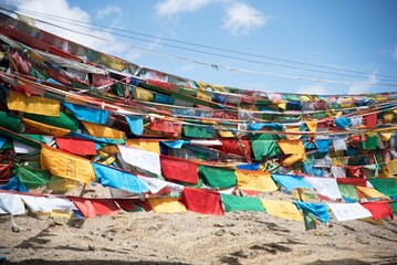 Close up of vibrant prayer flags fluttering hung between two hillsides