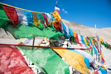 Vibrant display of prayer flags set against a  backdrop of rocks
