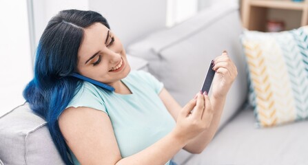 Young caucasian woman talking on the smartphone doing manicure at home