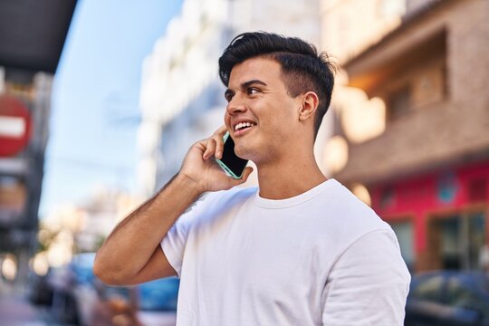 Young hispanic man smiling confident talking on the smartphone at street