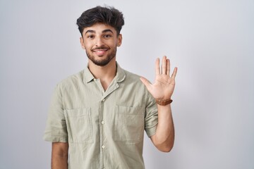 Fototapeta premium Arab man with beard standing over white background showing and pointing up with fingers number five while smiling confident and happy.