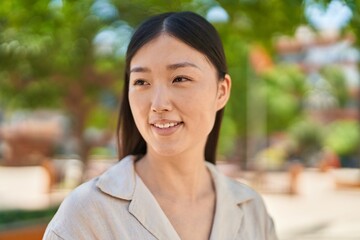 Chinese woman smiling confident looking to the side at park