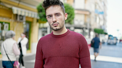 Fototapeta premium Young hispanic man standing with serious expression at street
