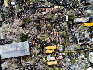 Drone photo of an abandoned junk yard with antique cars and tons of trash and pollution. 