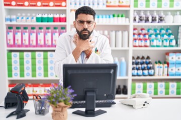 Hispanic man with beard working at pharmacy drugstore shouting and suffocate because painful strangle. health problem. asphyxiate and suicide concept.