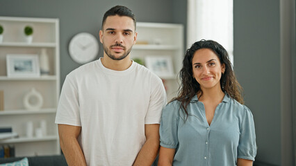 Man and woman couple standing together smiling at home