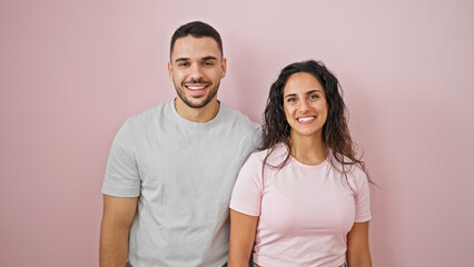 Obraz premium Man and woman couple smiling confident standing together over isolated pink background