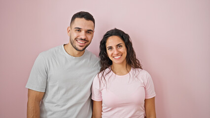 Obraz premium Man and woman couple smiling confident standing together over isolated pink background