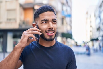 Young latin man smiling confident talking on the smartphone at street