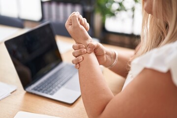 Young woman business worker suffering for wrist pain at office