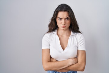 Fototapeta premium Young teenager girl standing over white background skeptic and nervous, disapproving expression on face with crossed arms. negative person.