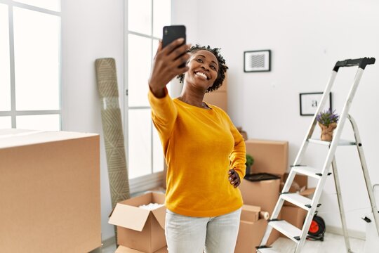 African american woman make selfie by smartphone standing at new home