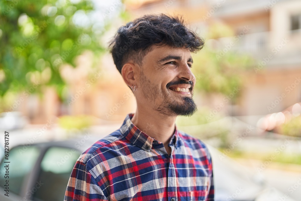 Sticker young hispanic man smiling confident looking to the side at street