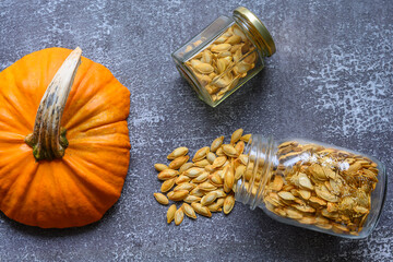 Two jars with pumpkin seeds on a rustic table