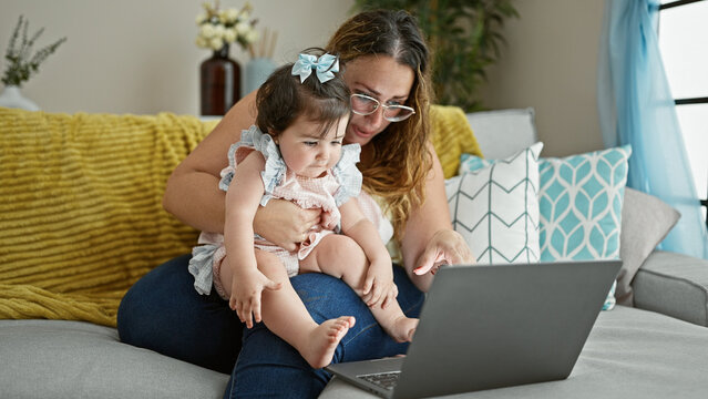 Heartwarming Scene Of Mother And Daughter, Sitting Together On The Sofa At Home, Engaging In A Serious Video Call On Their Laptop - Promoting The Love Of Family And The Power Of Modern Technology.