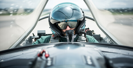 Fighter pilot cockpit view.  Fighter Pilot in flight wearing flying helmet, dark visor and oxygen mask  - obrazy, fototapety, plakaty