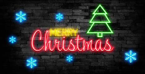 Obraz premium Merry Christmas shiny neon lamps sign glow on black brick wall. colorful sign board with text Merry Christmas and Christmas tree for party decoration.