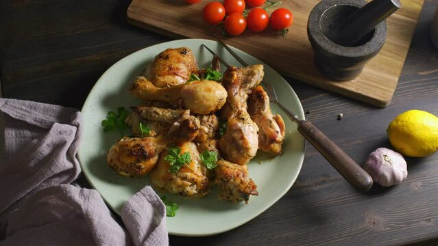 Chicken drumsticks on a plate are served to the table