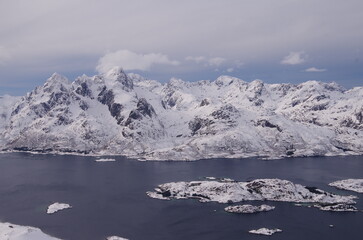 Fototapeta na wymiar Lofoten Islands in winter time: ski touring, snowy mountains, red houses, fishermen boats and scenic landscapes