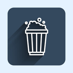 White line Popcorn in cardboard box icon isolated with long shadow background. Popcorn bucket box. Blue square button. Vector