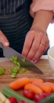 Vegetables knife, hands and person cutting celery, ingredients and prepare food on wooden board. Nutritionist salad, kitchen utensils tools or closeup chef slice carrot, tomato and cooking dinner
