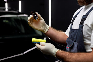 auto mechanic worker going to clean car with cloth and oil liquid, car detailing or valeting...