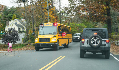 Fototapeta premium yellow school bus stopping on residential street