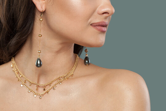 Gold jewelry necklace and long earring with black pearls, fashion studio portrait closeup