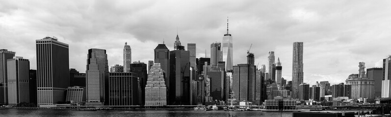 A black and white scene of the cityscape of New York City, with skyscrapers piercing the skyline