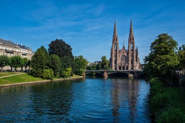 Fototapeta na wymiar Landscape view of the Cathedral of Strasbourg with a picturesque river under it