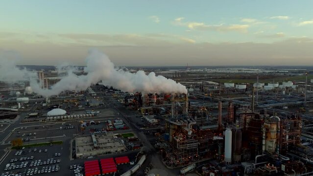 Sunset over factory smoke. Aerial drone video of an industrial factory 4k