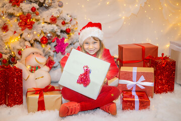 Fototapeta na wymiar Pretty little girl looking forward to opening Christmas presents