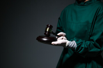 Doctor surgeon hold a hammer of justice and law on medical healthcare concept,wearing scrub overall...