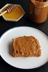 Peanut butter sandwich with honey on a black background