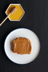 Peanut butter sandwich with honey on a black background