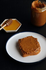 Peanut butter sandwich with honey on a black background