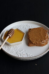Peanut butter sandwich with honey on a black background
