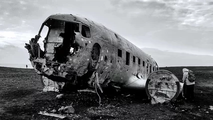Wall murals Old airplane Grayscale shot of an old crashed plane in a field.
