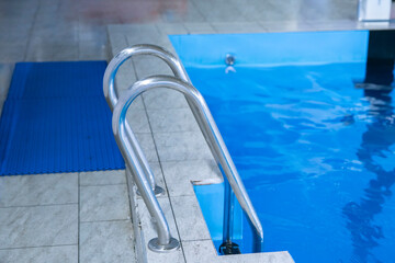 a stairs with handrails in the swimming pool inside the big sport center