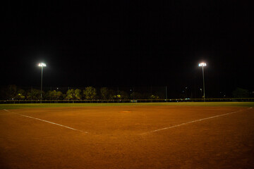 Empty baseball field at night, view from home plate