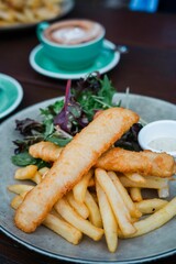Vertical shot of a plate with fish sticks, french fries, and salad