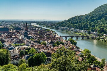Aerial view of Heidelberg cityscape near a river and green mountains in Germany