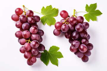 Fototapeta premium Isolated top-view of partially sliced red grapes, adorned with verdant leaves, on a white background.