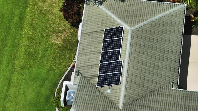 Aerial view of regular American home roof with blue solar photovoltaic panels for producing clean ecological electric energy. Renewable electricity with zero emission concept