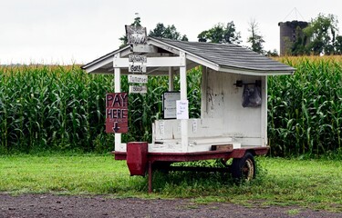 an old wooden and white outhouse with a porch marijuana signs on it