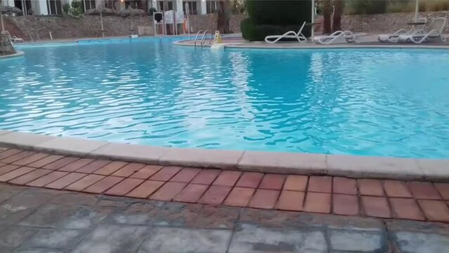 A swimming pool, umbrellas and seats are in Naama Bay, Sharm El Sheikh, South Sinai, Egypt. Sharm El Sheikh is a landmark in Egypt.
