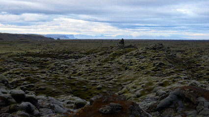 mountains and vatnajökull glacier in the background of mossy lava field in iceland