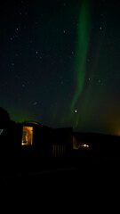 aurora borealis behind sauna in iceland