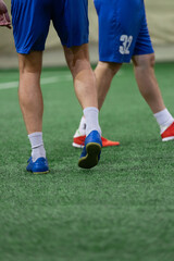 Five-a-side players walking on mini soccer terrain during the match.